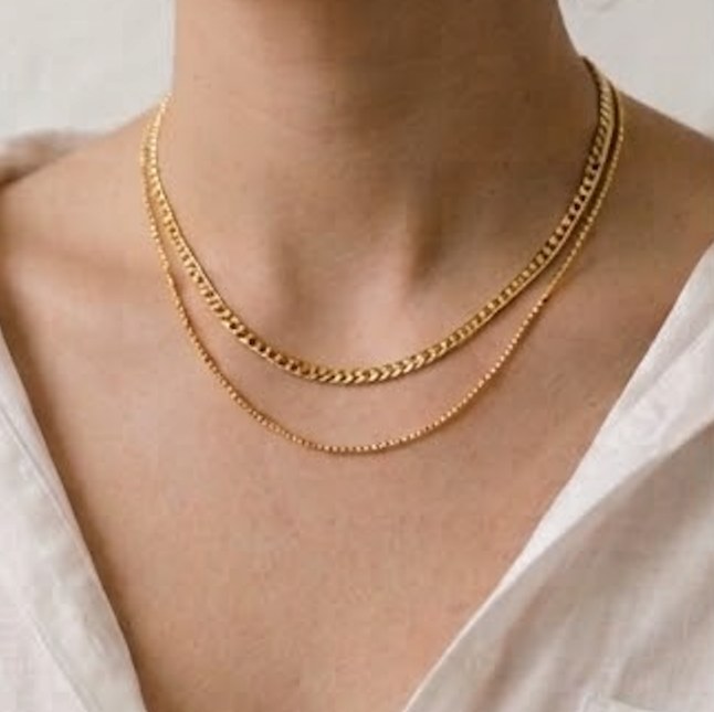 Fine gold chains at the neckline.